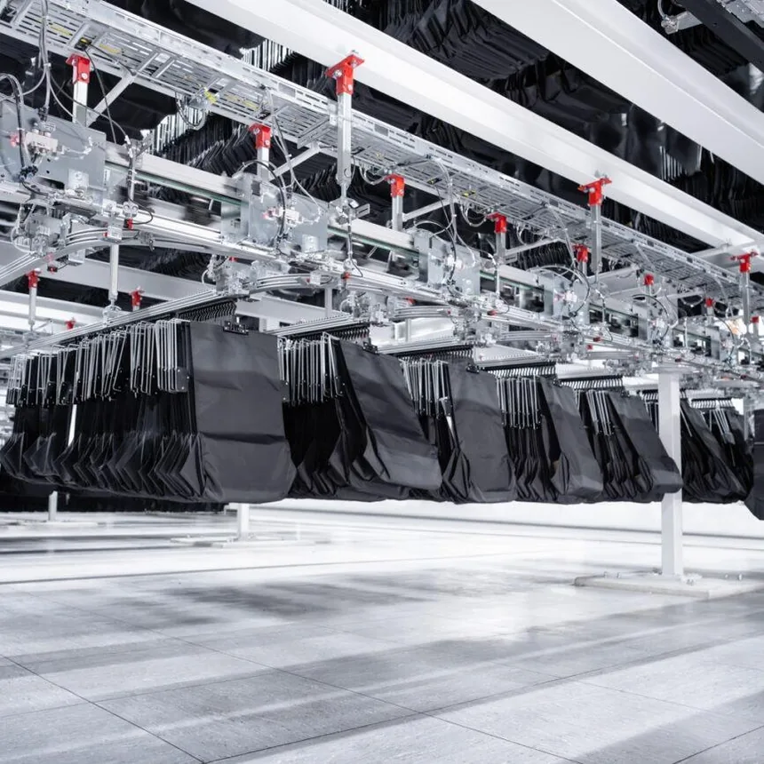 Production reference showing black fabric pieces suspended along a production line